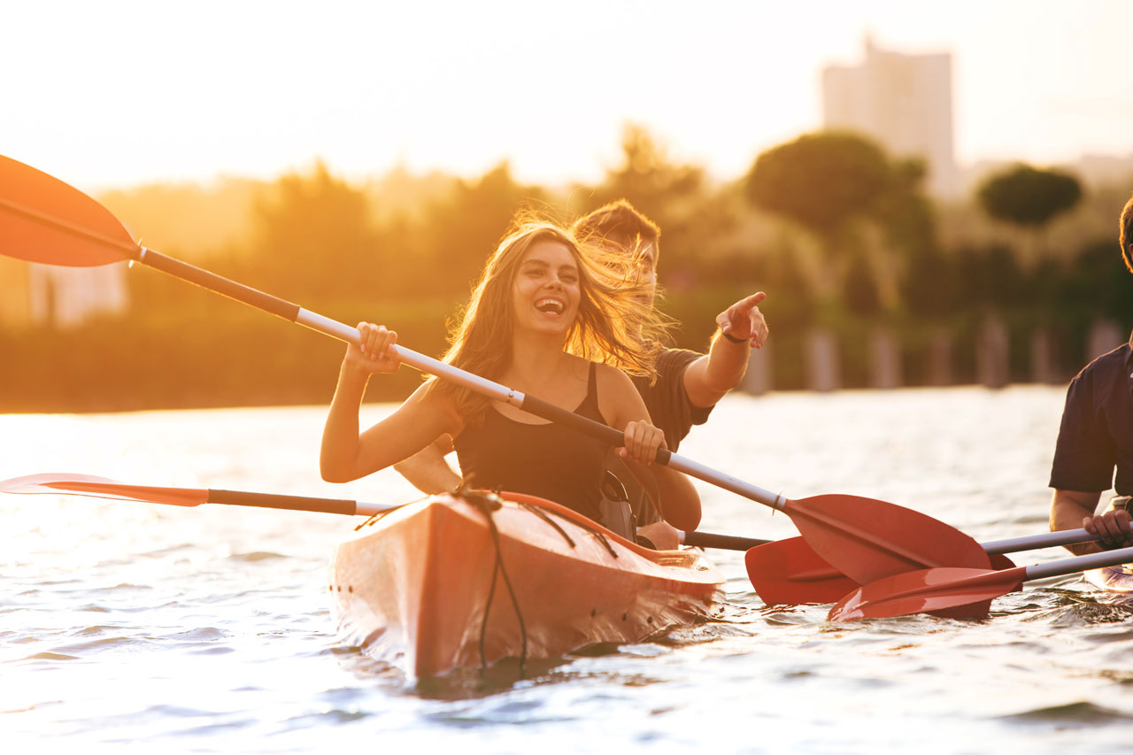 A happy couple enjoying clear bottom kayak rentals in San Diego at sunset, perfect for Valentine’s Day adventures.